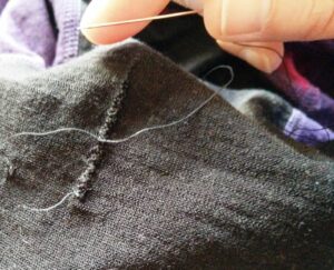 With the garment inside out, insert the threaded needle and secure the thread to the fabric with a knot or two.