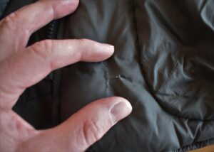 How to Repair a Down Jacket - stitched-up tear between zipper and hand pocket