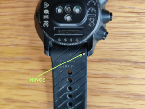 Push the metal hinge towards the middle of the strap to detach it